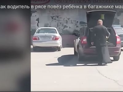 Священник сажает ребенка в багажник. Фото: скриншот видео Священник сажает ребенка в багажник. Фото: скриншот видео
