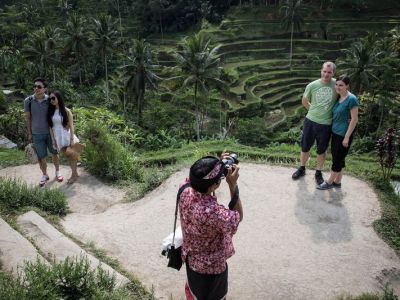Гид фотографирует пару туристов на рисовой террасе на Бали. Фото: Agung Parameswara/Getty Images