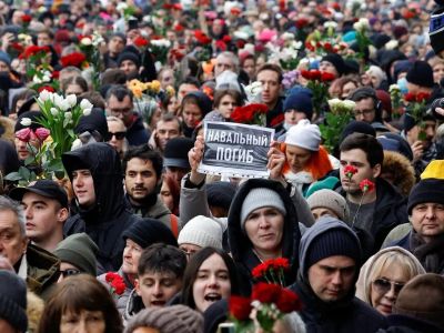 Скорбящие идут на Борисовское кладбище во время похорон Алексея Навального. На плакате написано: "Навальный погиб".Фото: Reuters